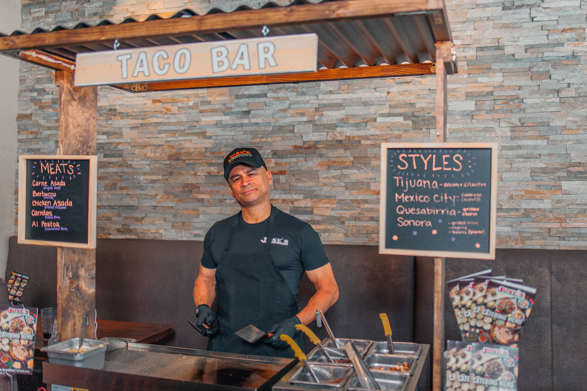 José's taco bar setup with meats and styles menu boards